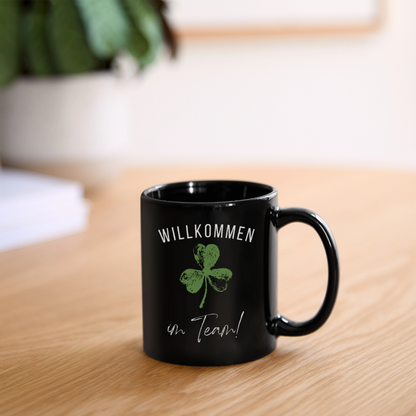 Schwarze Tasse "Willkommen im Team" (Kleeblatt) - Schwarz